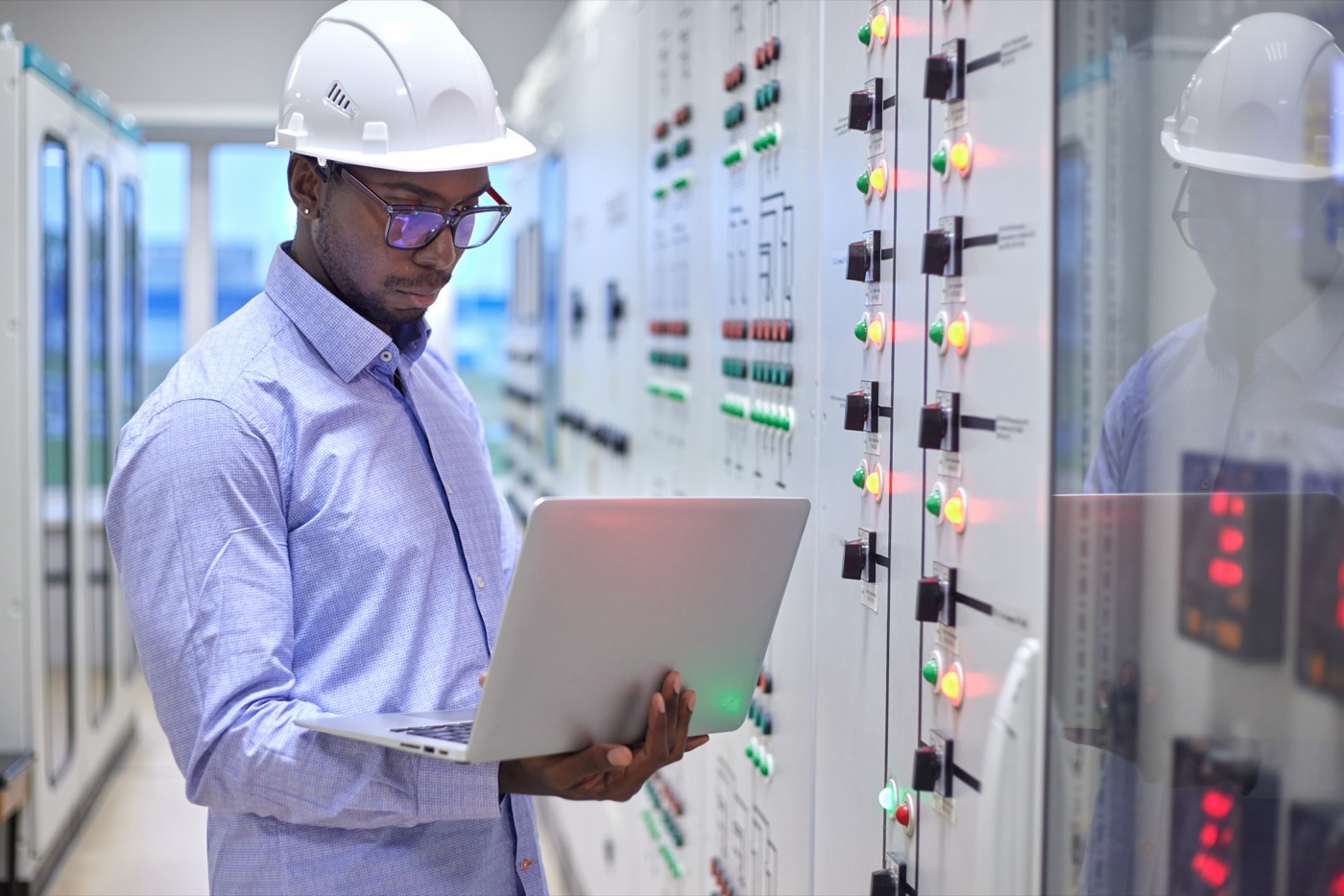 Engineer at a control panel with a laptop