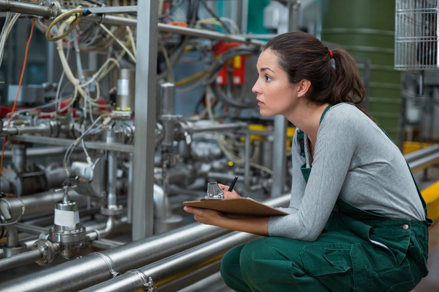 Technician inspecting process piping